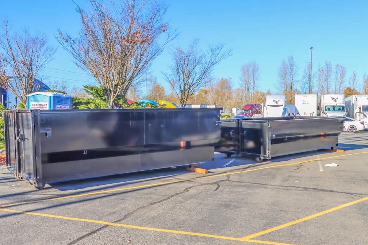 Professional dumpster rental service with roll-off container on residential driveway in Charlestown